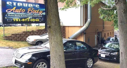Steve's Auto Body sign and vehicles parked outside the Norwell shop